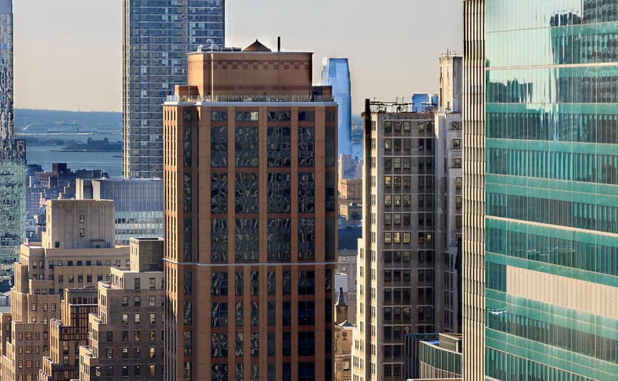 A cluster of modern high-rise buildings and skyscrapers with glass and brick facades in sunlight. The letters FPO in large pink font are overlaid at the center of the image.